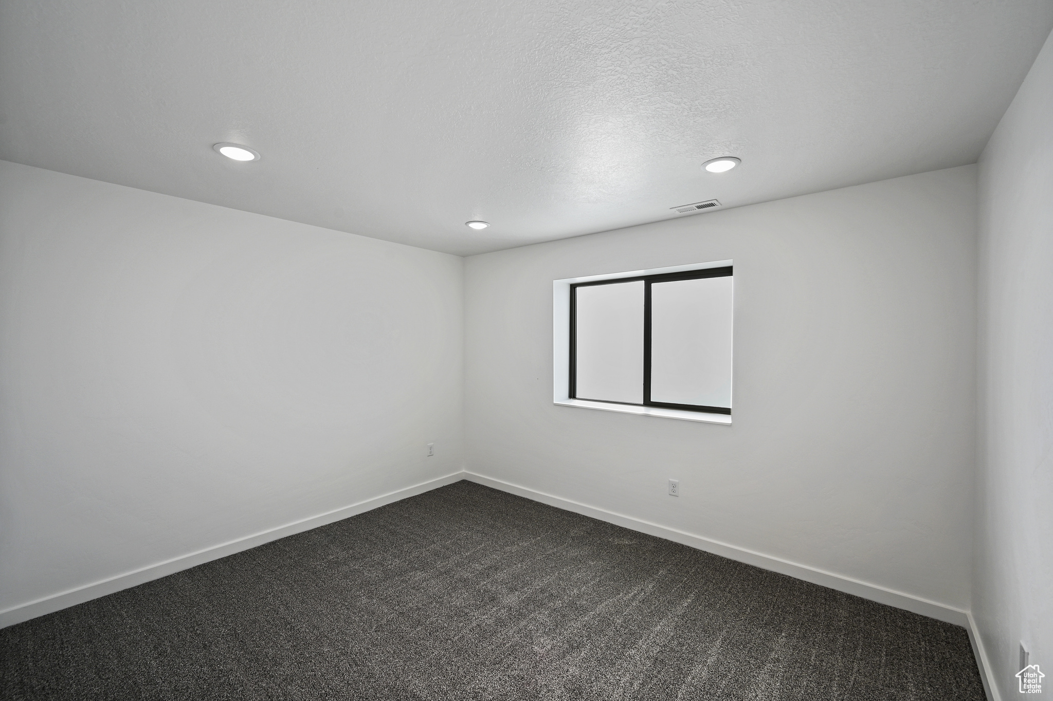 Unfurnished room featuring carpet floors and a textured ceiling