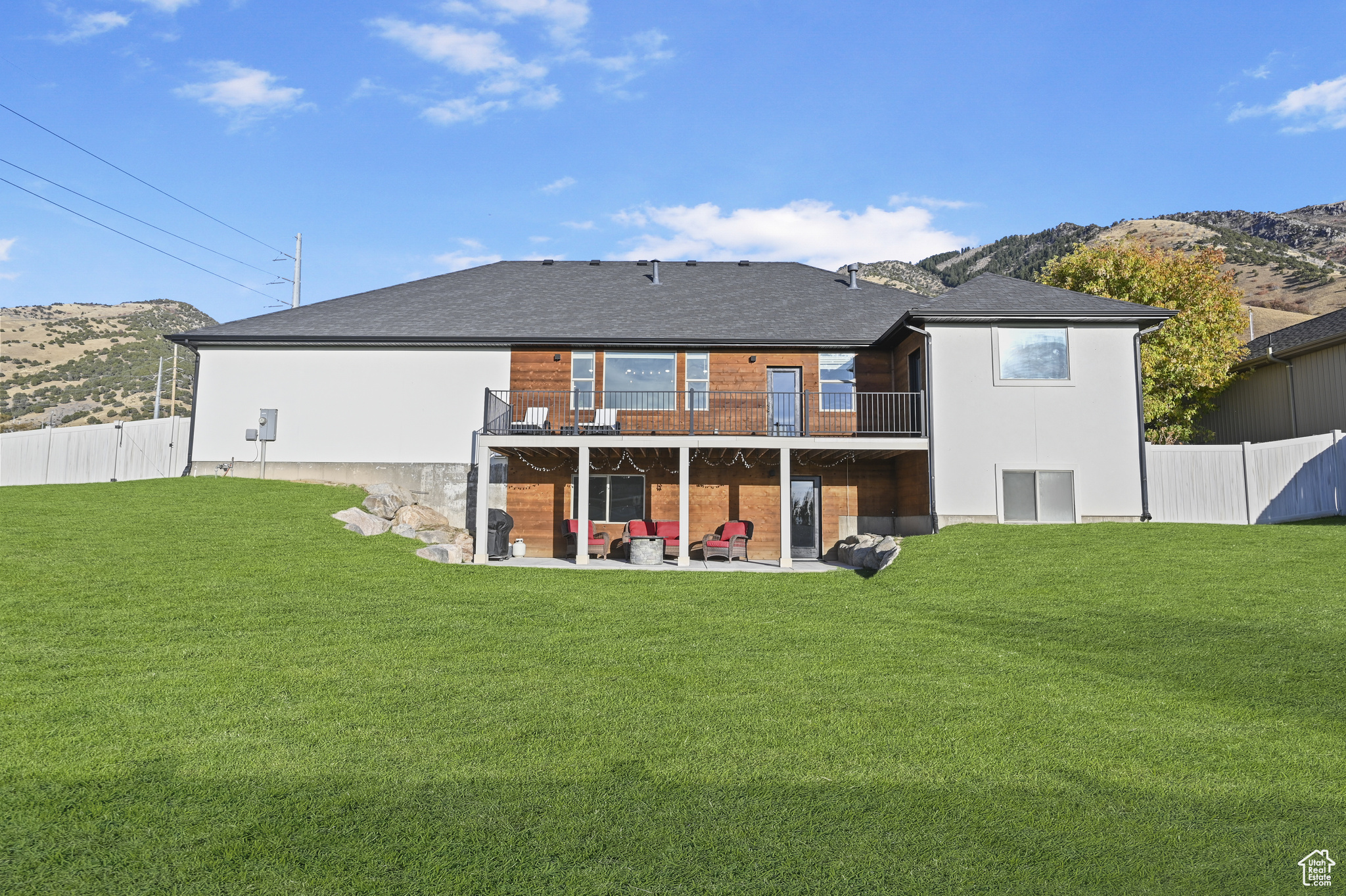 Back of house featuring a yard, a patio area, and a mountain view