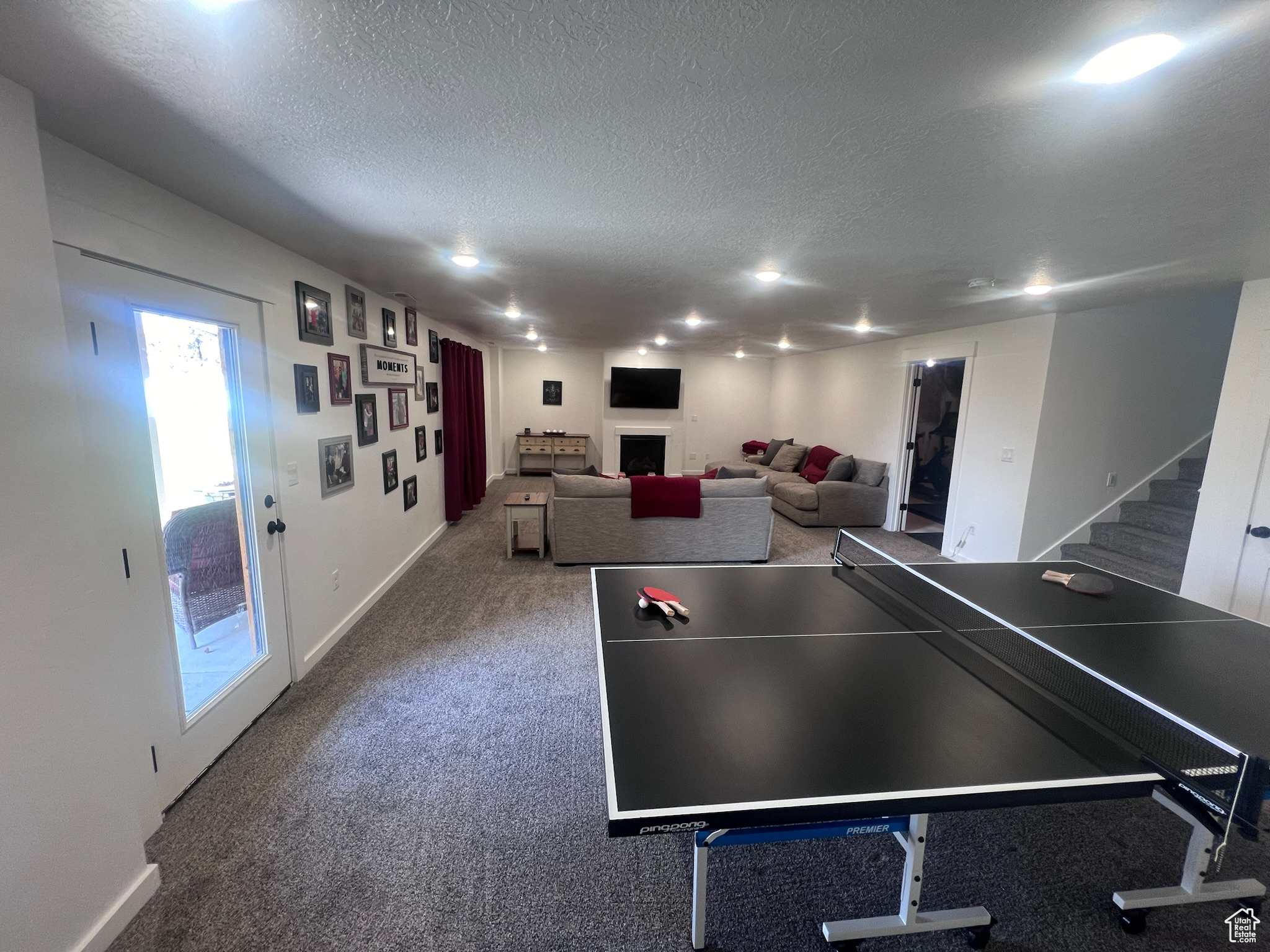 Game room featuring carpet and a textured ceiling