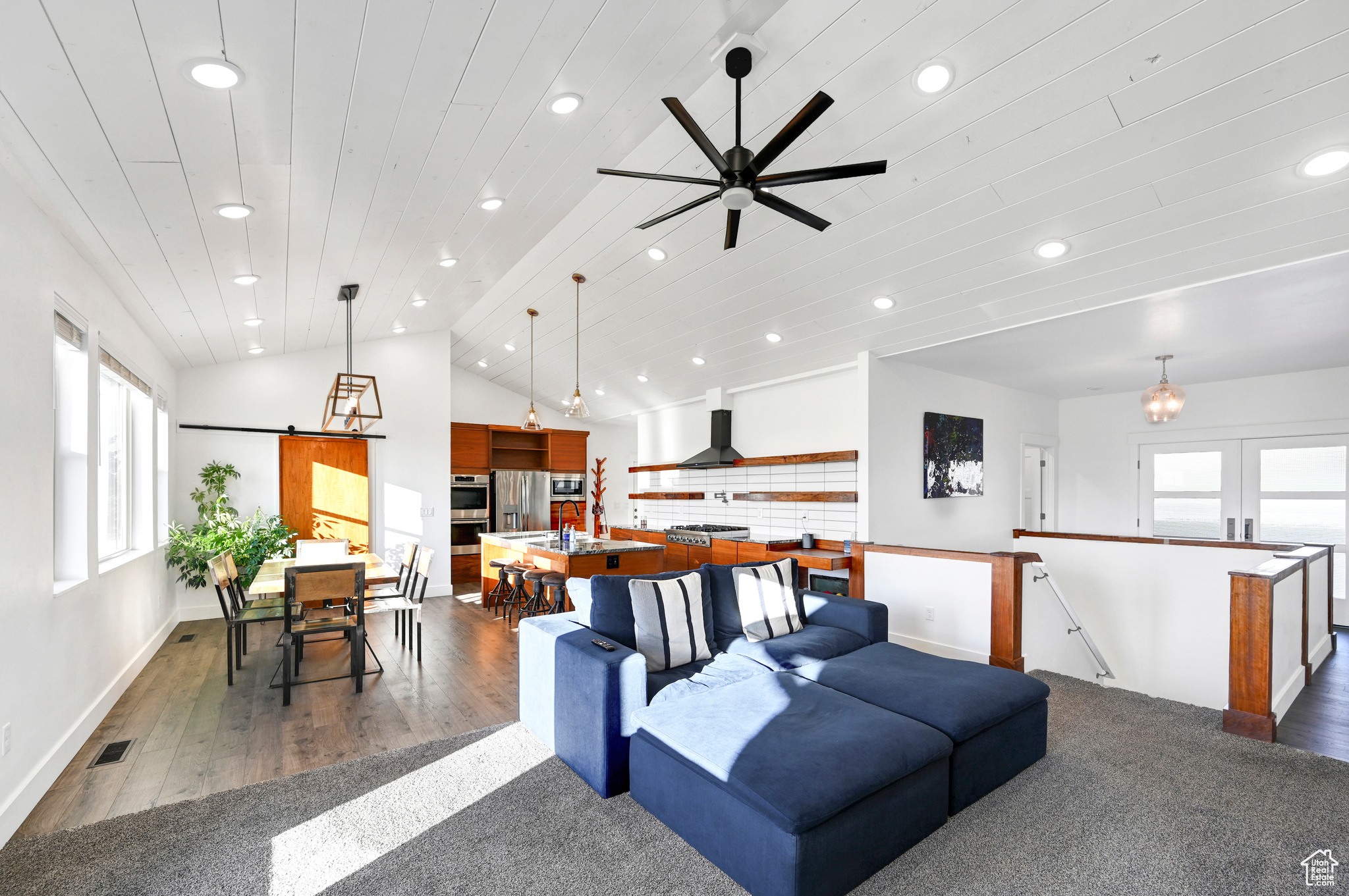 Living room with dark wood-type flooring, wood ceiling, vaulted ceiling, and ceiling fan