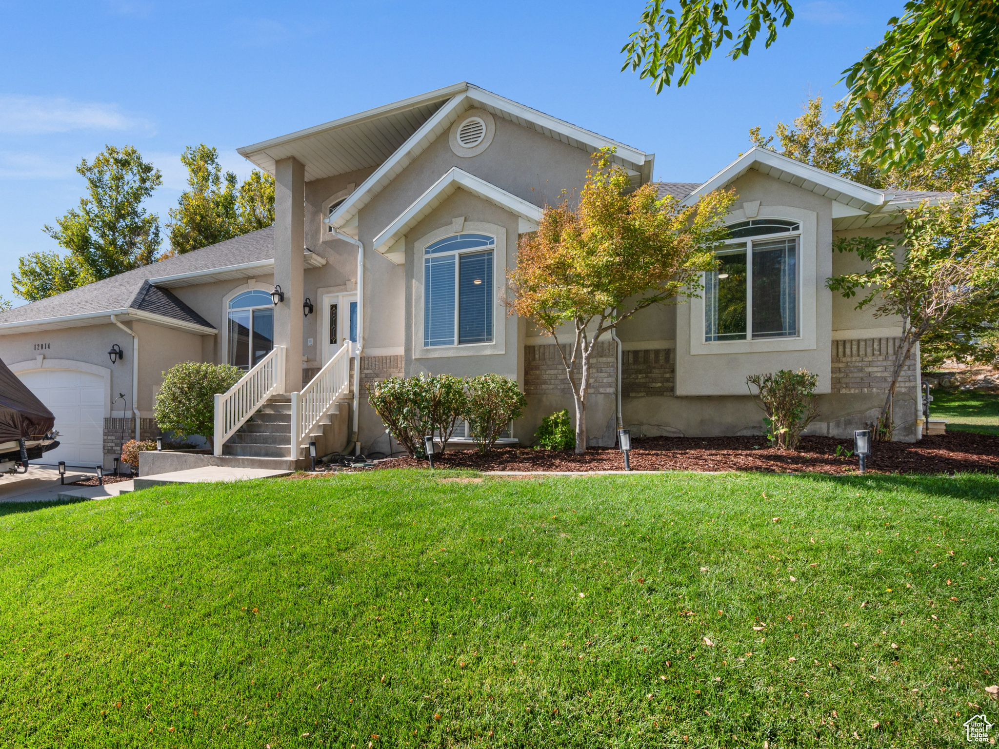 View of front of property featuring a front yard and a garage