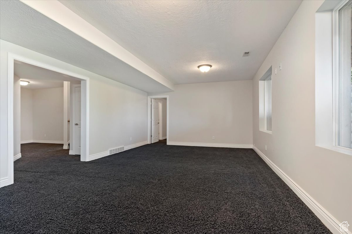 Carpeted empty room with a textured ceiling