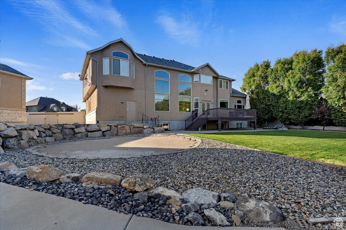 Rear view of property featuring a yard, a patio area, and a deck