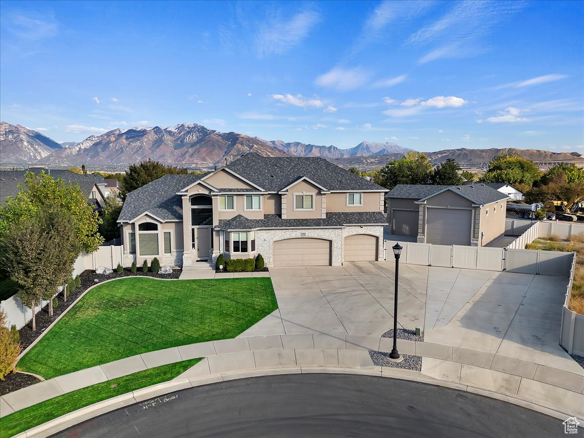 View of front of house featuring a garage, a front yard, and a mountain view