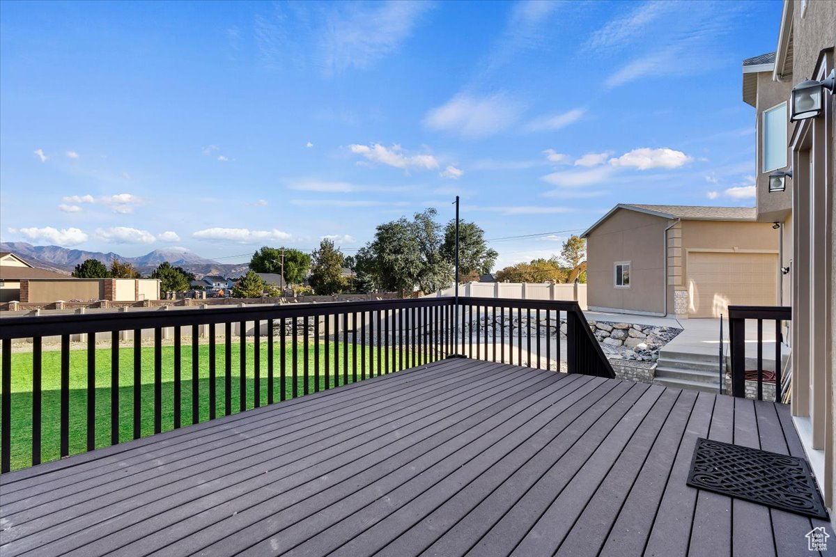 Wooden terrace featuring a mountain view and a yard