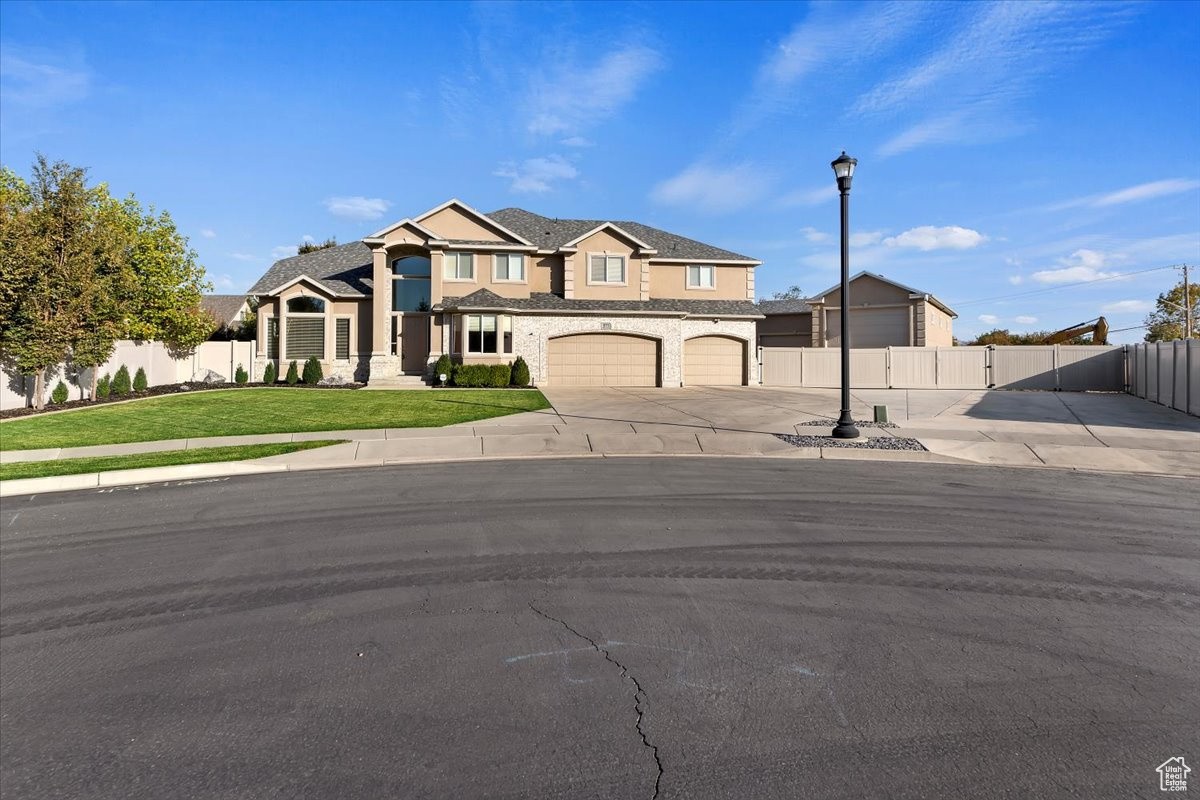 View of front of house featuring a garage and a front lawn