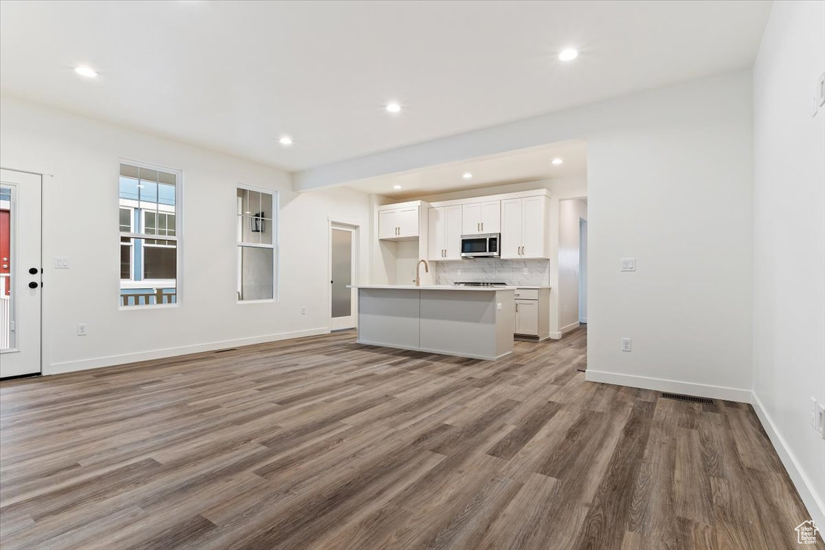 Unfurnished living room with sink and hardwood / wood-style flooring