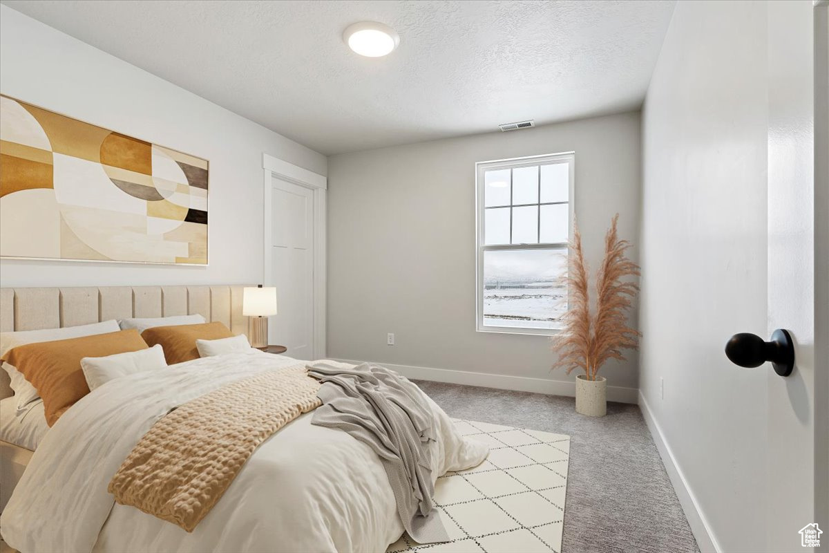 Carpeted bedroom featuring a textured ceiling