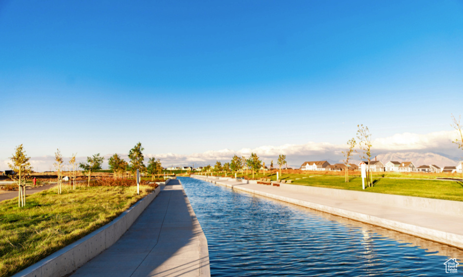 View of property's community featuring a water view and a yard