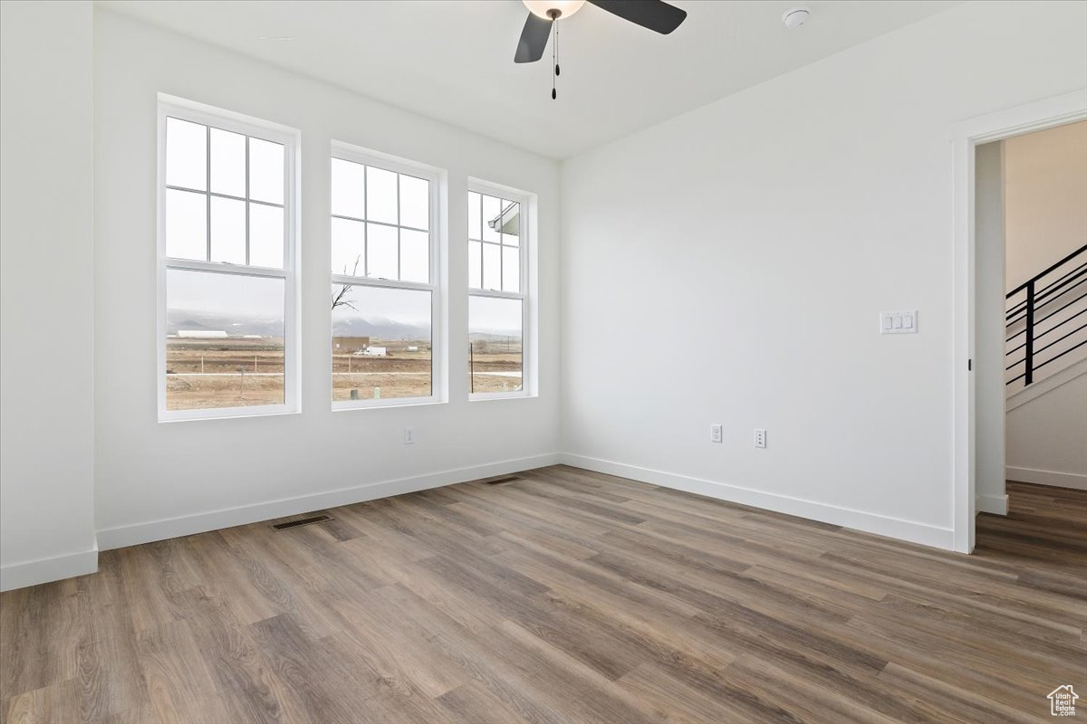 Unfurnished room featuring hardwood / wood-style floors and ceiling fan