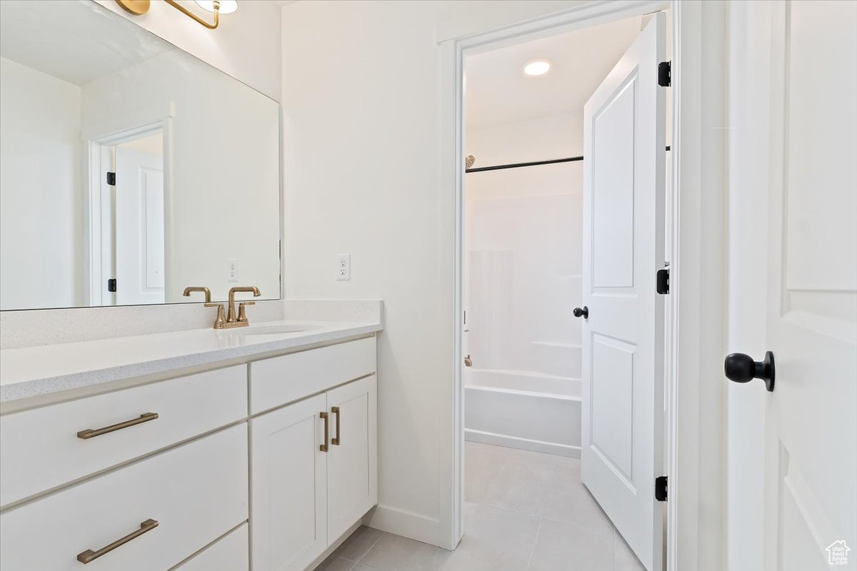 Bathroom featuring tile patterned flooring, vanity, and tub / shower combination