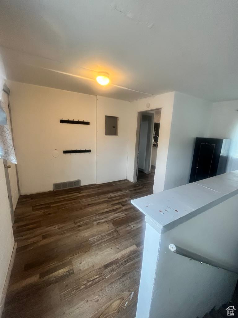 Laundry room featuring electric panel and dark hardwood / wood-style floors