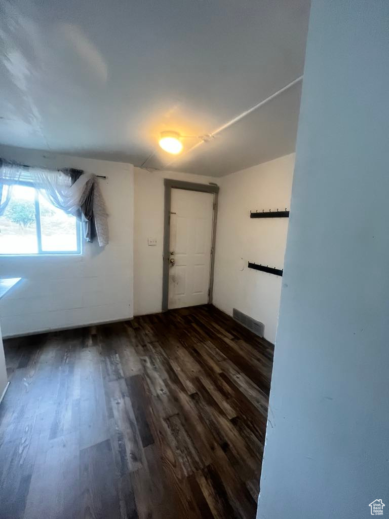 Empty room with dark hardwood / wood-style floors