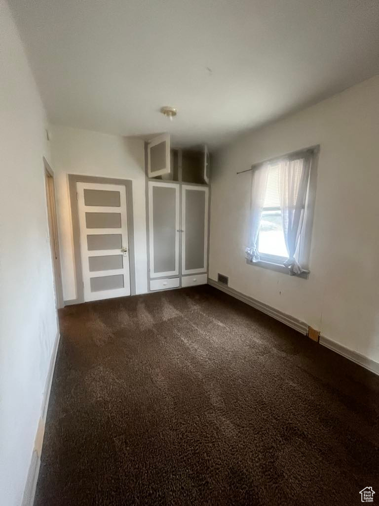 Unfurnished bedroom featuring dark colored carpet