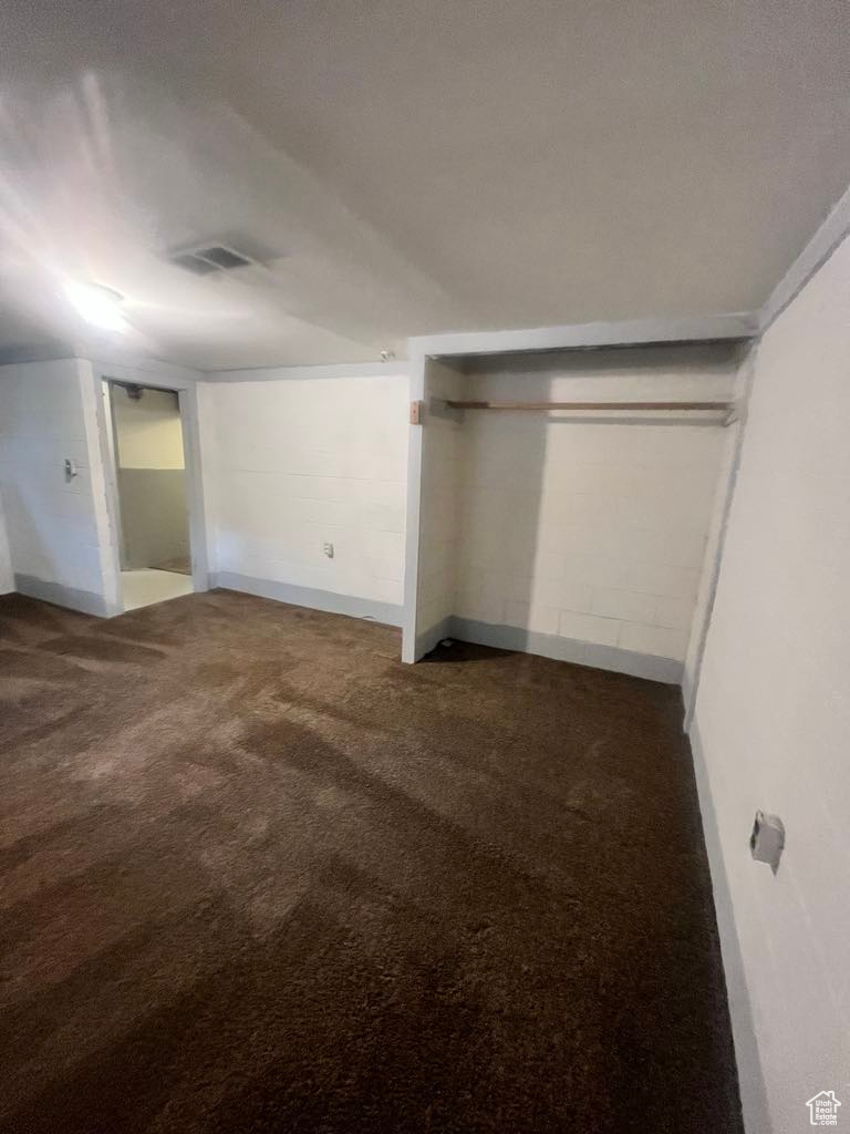 Unfurnished bedroom with dark colored carpet