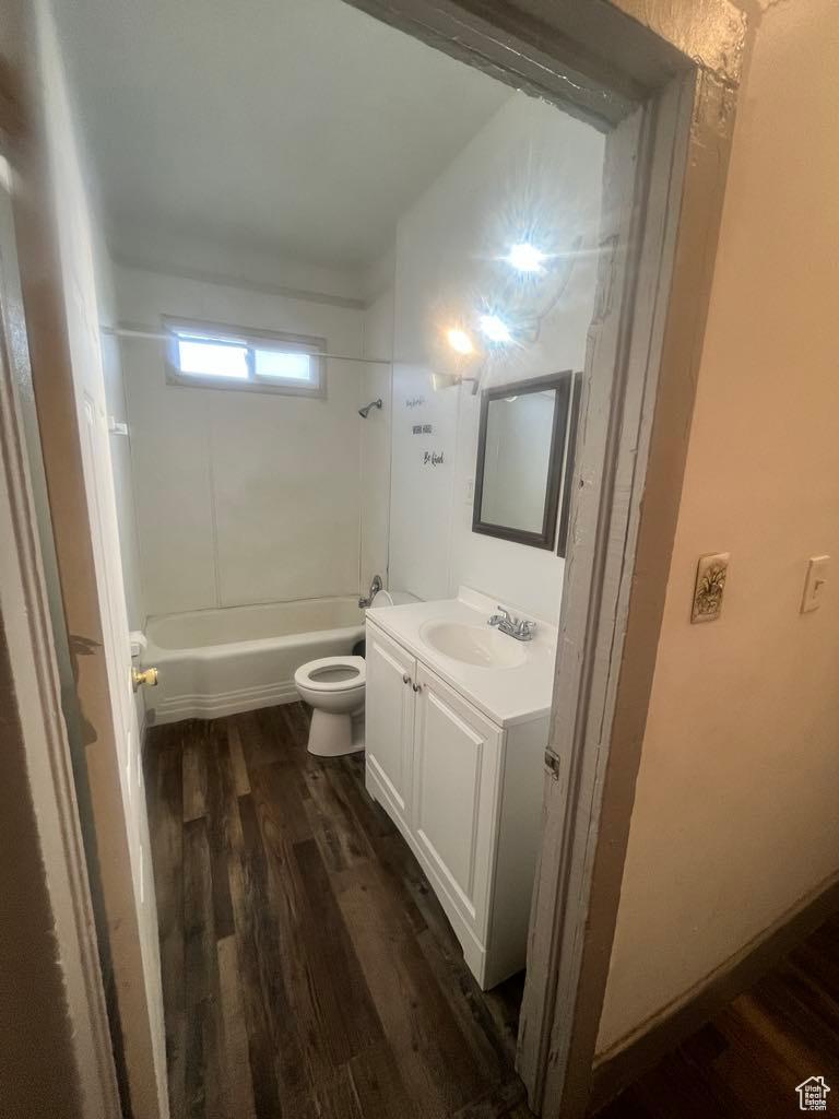 Full bathroom featuring bathing tub / shower combination, wood-type flooring, vanity, and toilet