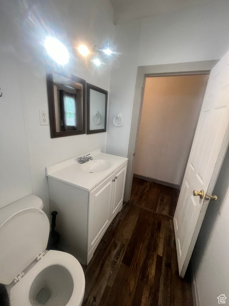 Bathroom featuring hardwood / wood-style flooring, vanity, and toilet