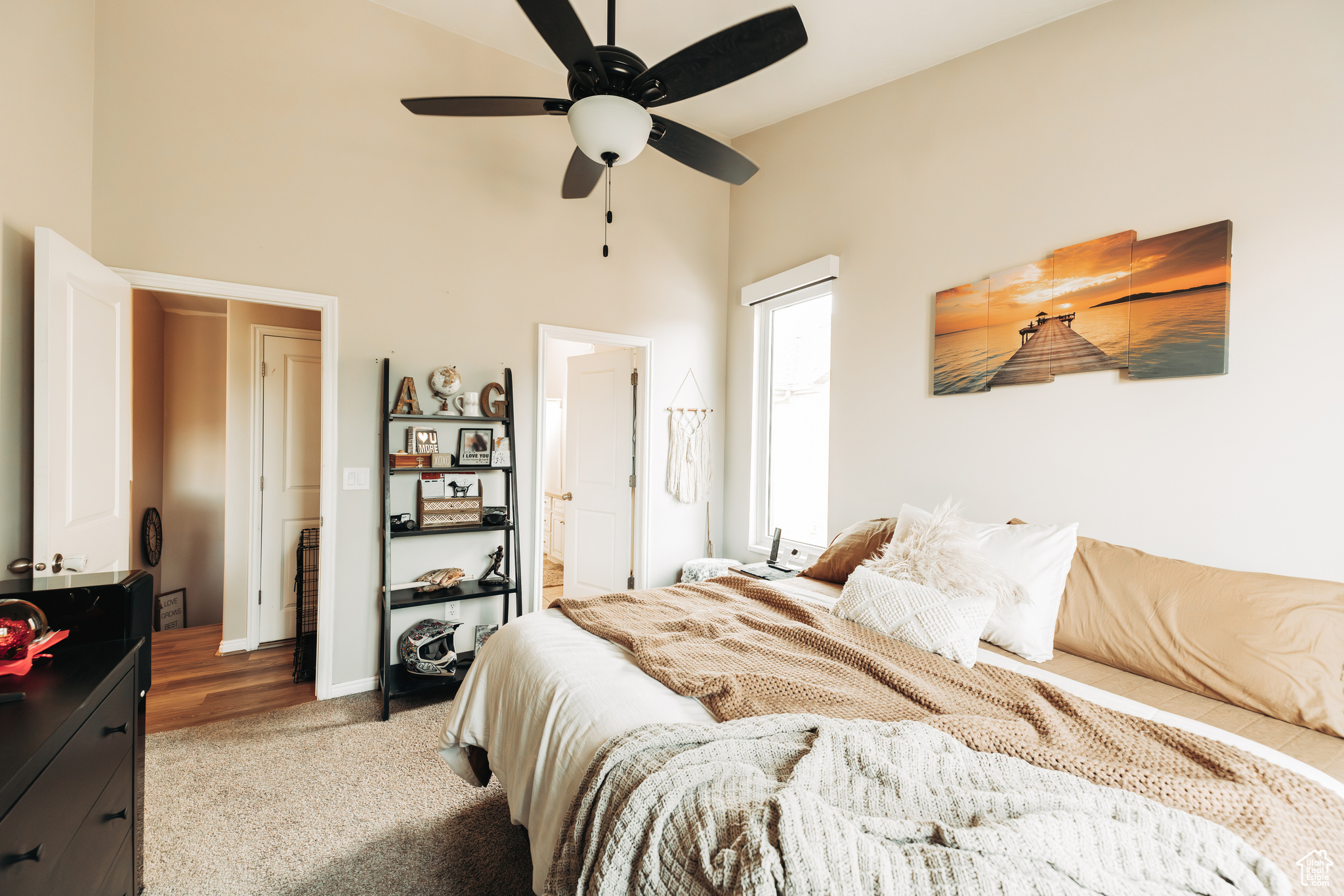 Bedroom featuring carpet, connected bathroom, a towering ceiling, and ceiling fan