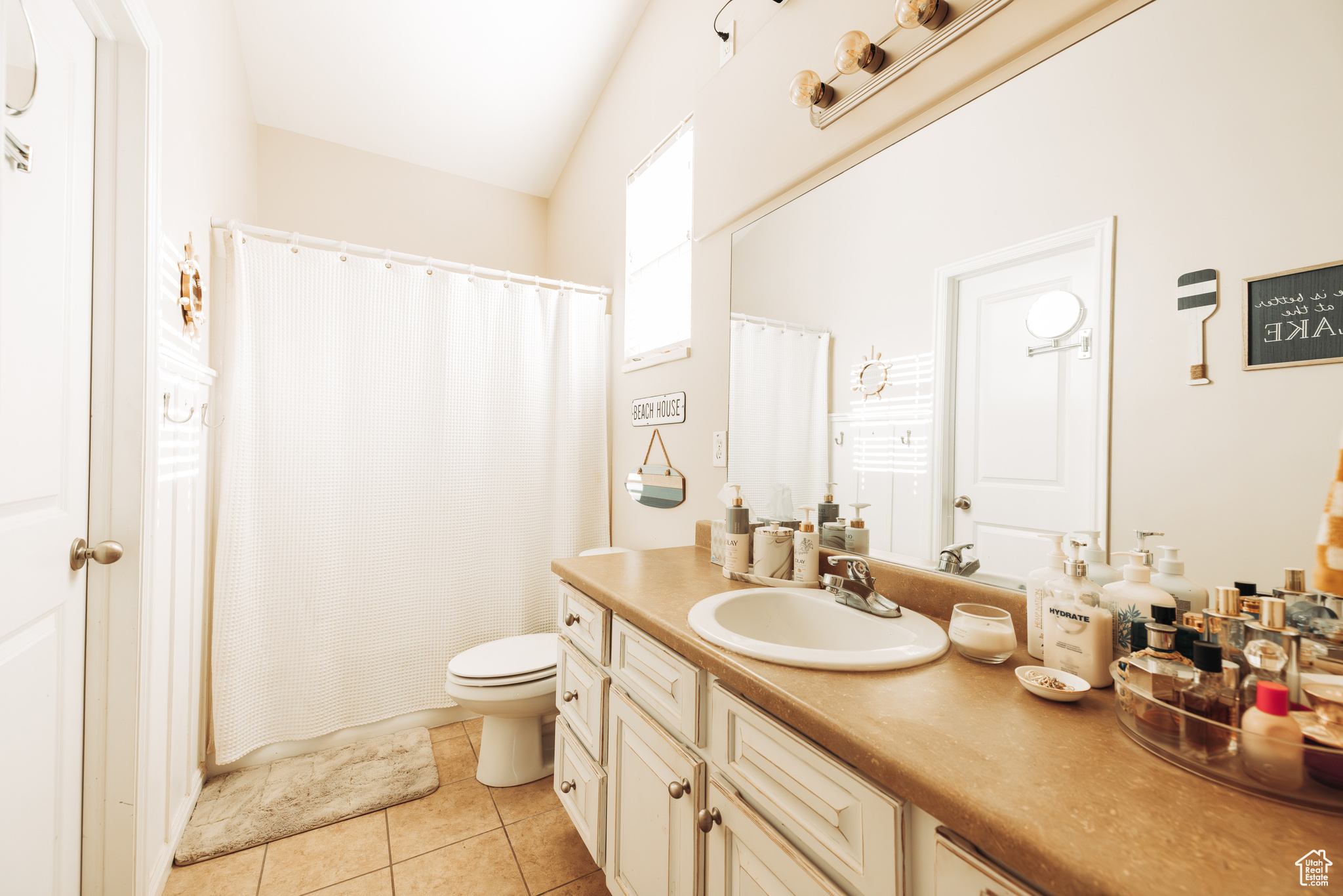 Bathroom featuring tile patterned floors, toilet, walk in shower, and vanity