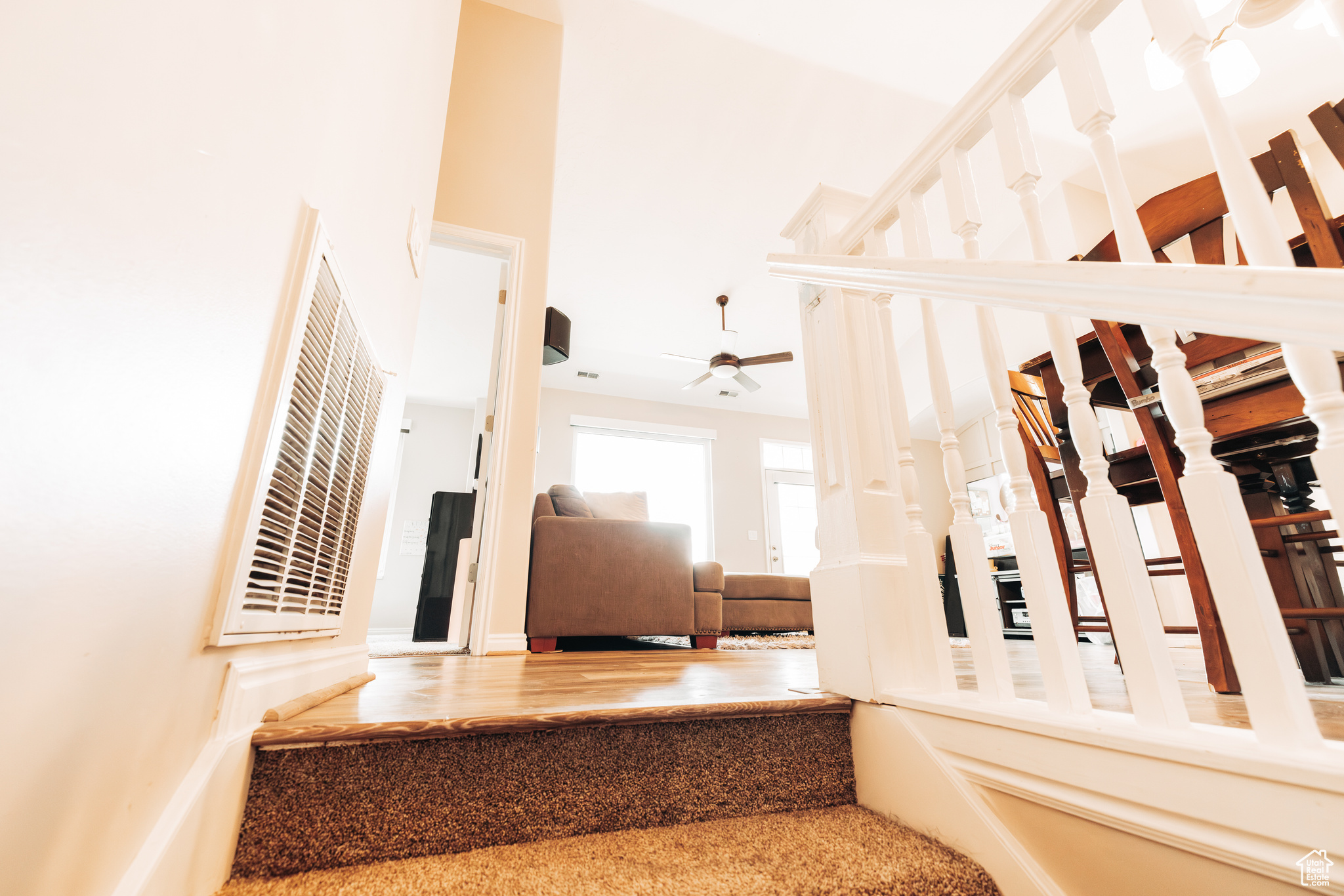 Stairs with hardwood / wood-style flooring and ceiling fan