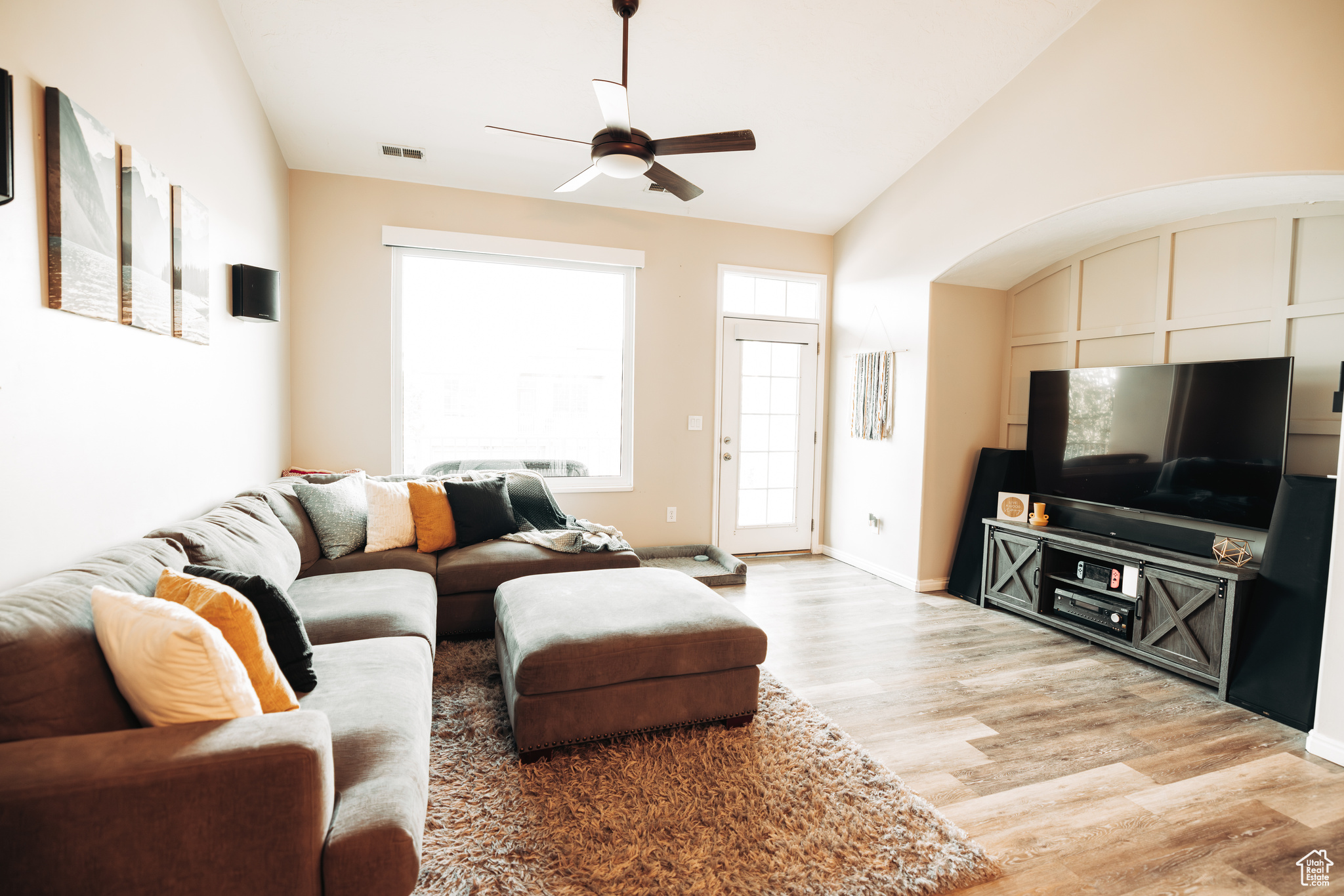 Living room with vaulted ceiling, hardwood / wood-style flooring, and ceiling fan