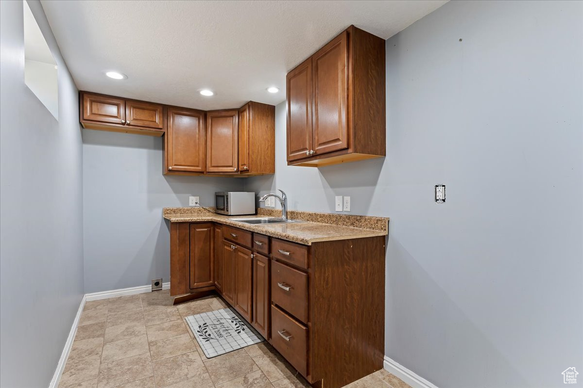 Kitchen featuring light stone countertops and sink