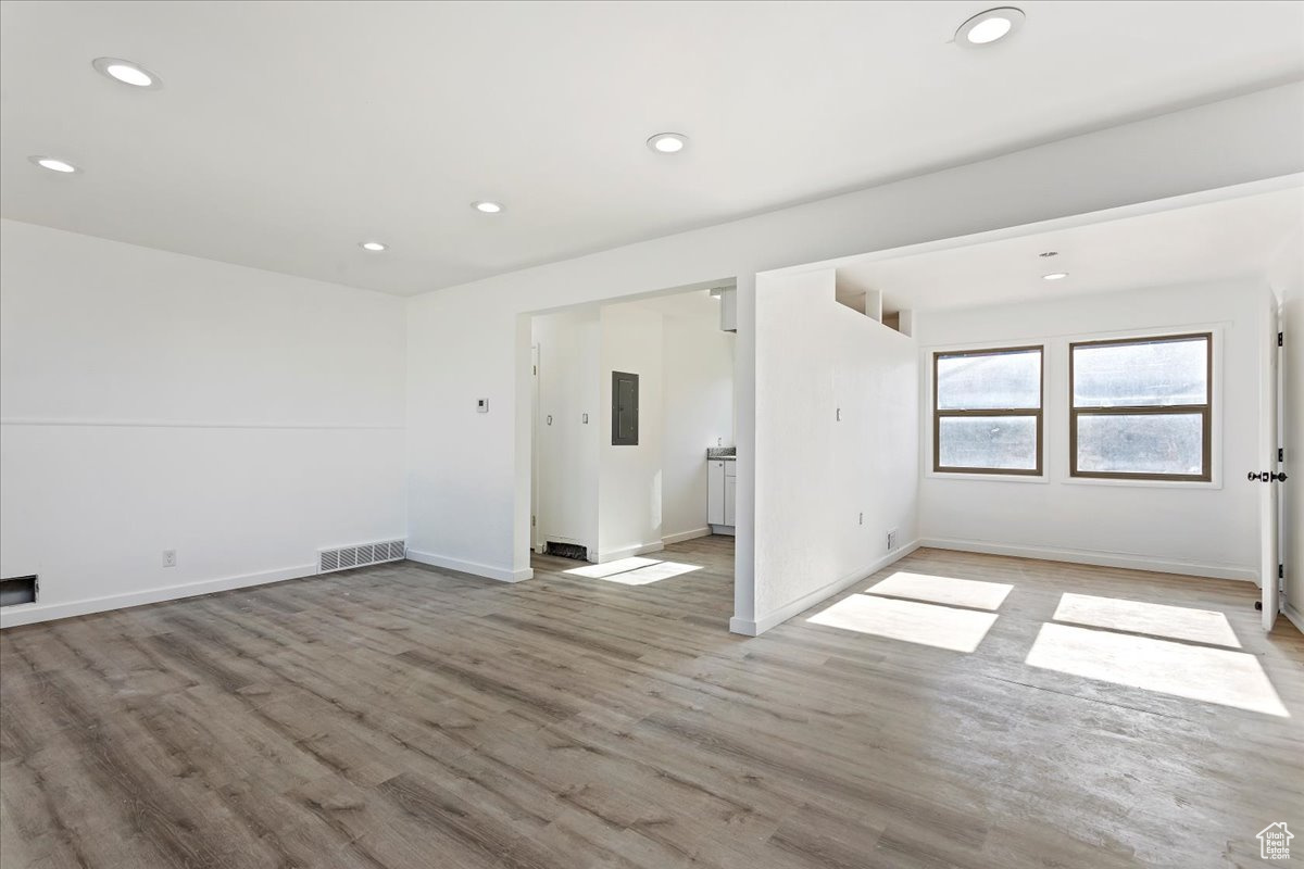 Empty room featuring electric panel and light hardwood / wood-style flooring