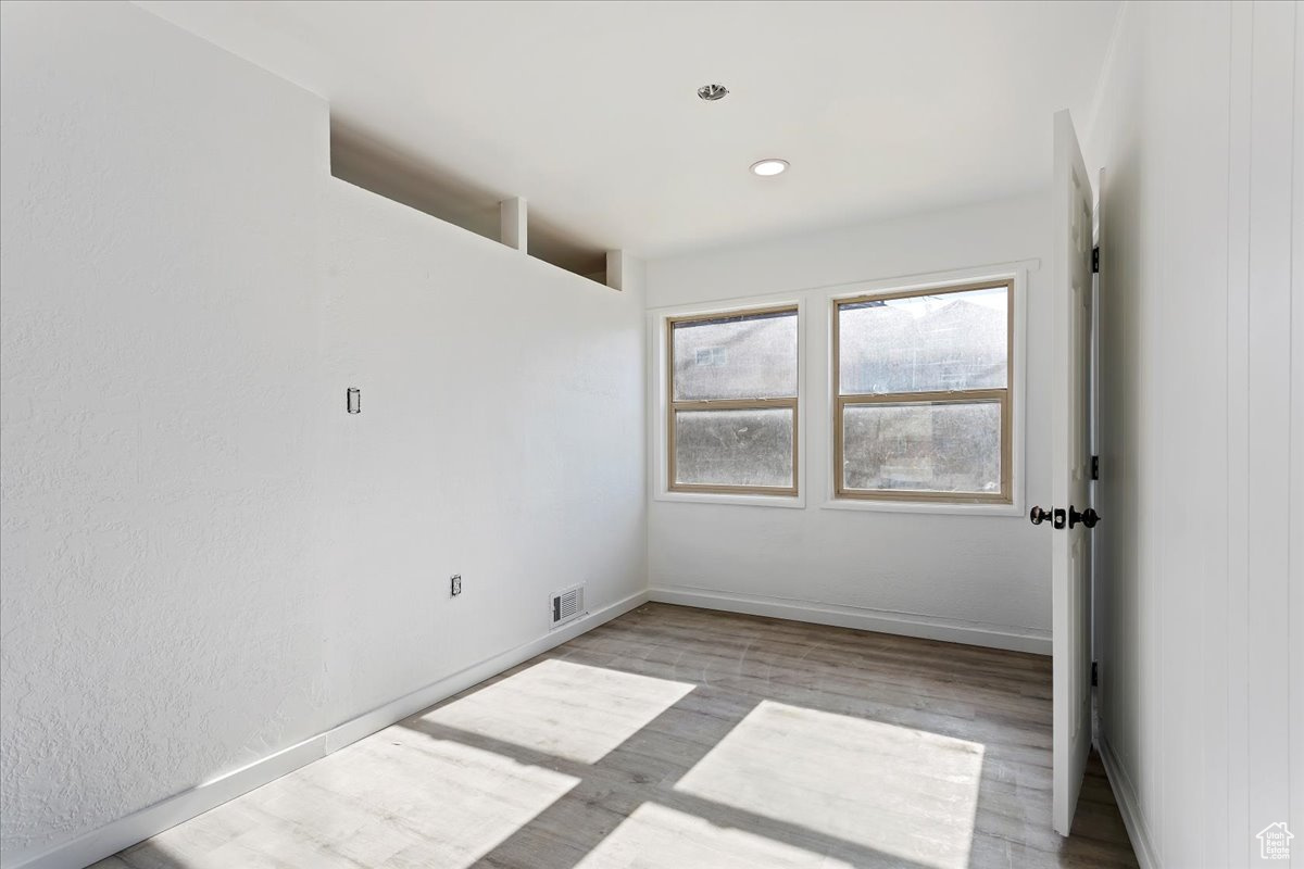 Empty room with light hardwood / wood-style floors