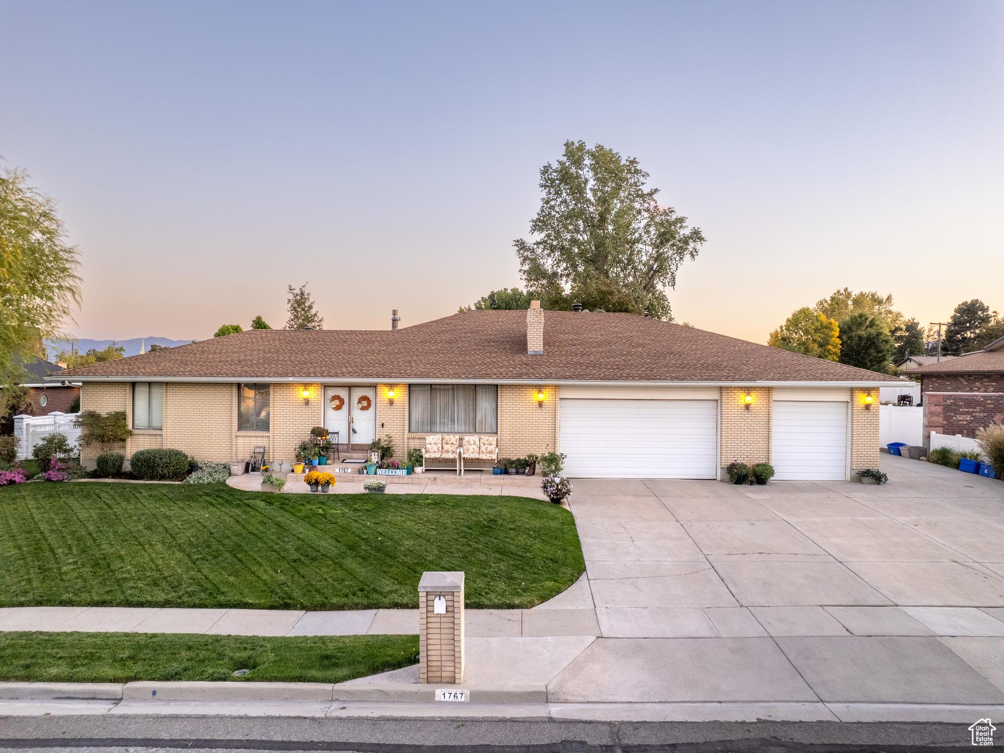 Ranch-style house featuring a garage and a yard