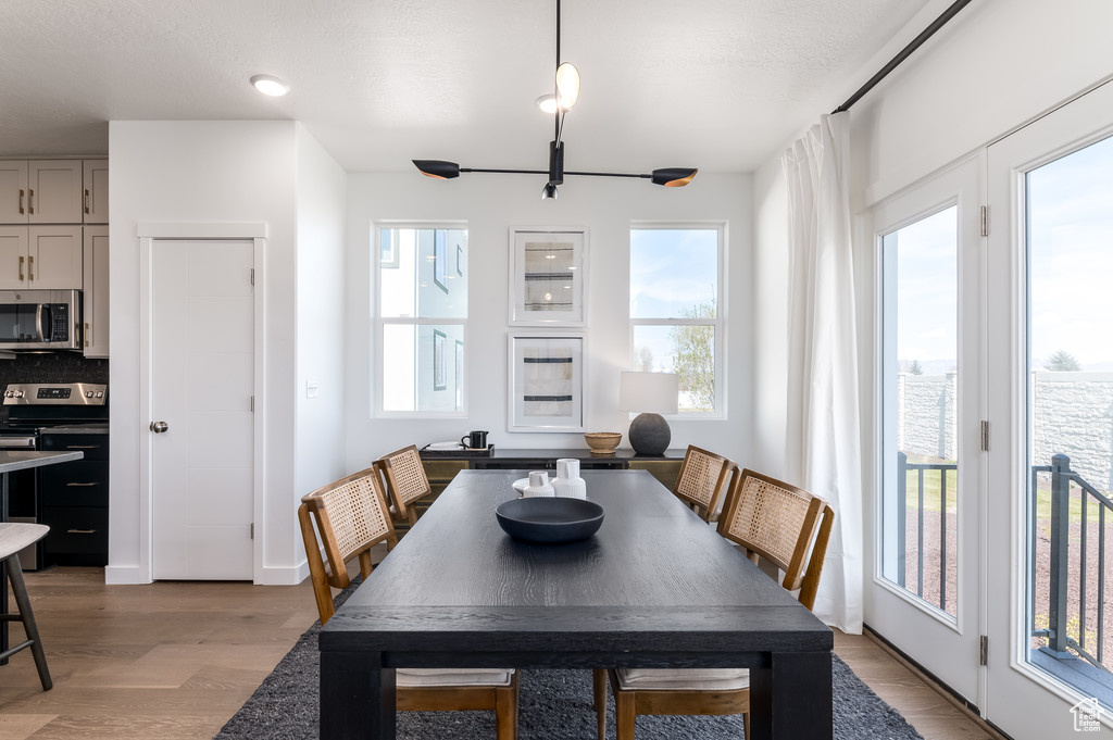 Dining area with a notable chandelier and light hardwood / wood-style flooring