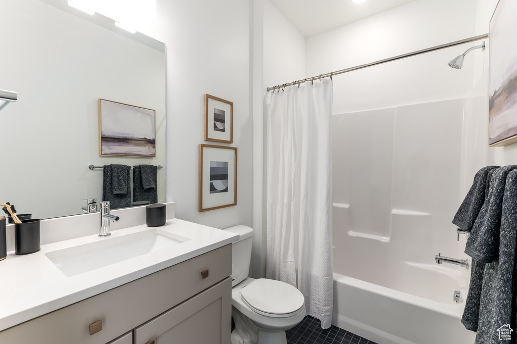 Full bathroom with shower / bath combo, tile patterned floors, toilet, and vanity