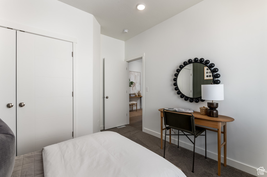 Bedroom featuring a closet and dark colored carpet