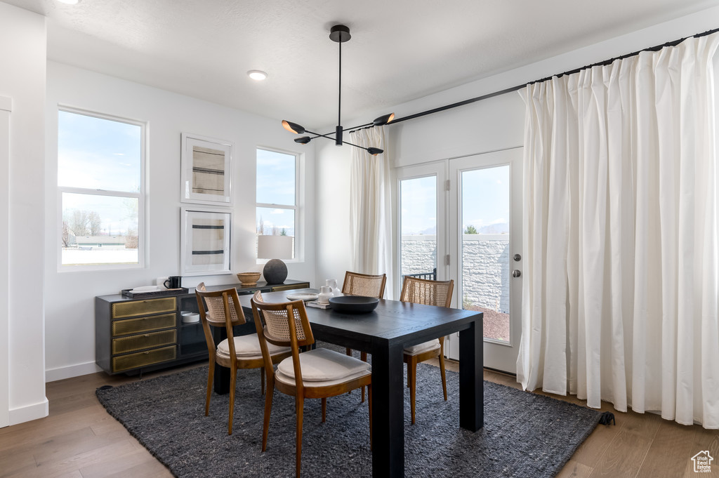 Dining area featuring an inviting chandelier, plenty of natural light, and light hardwood / wood-style floors