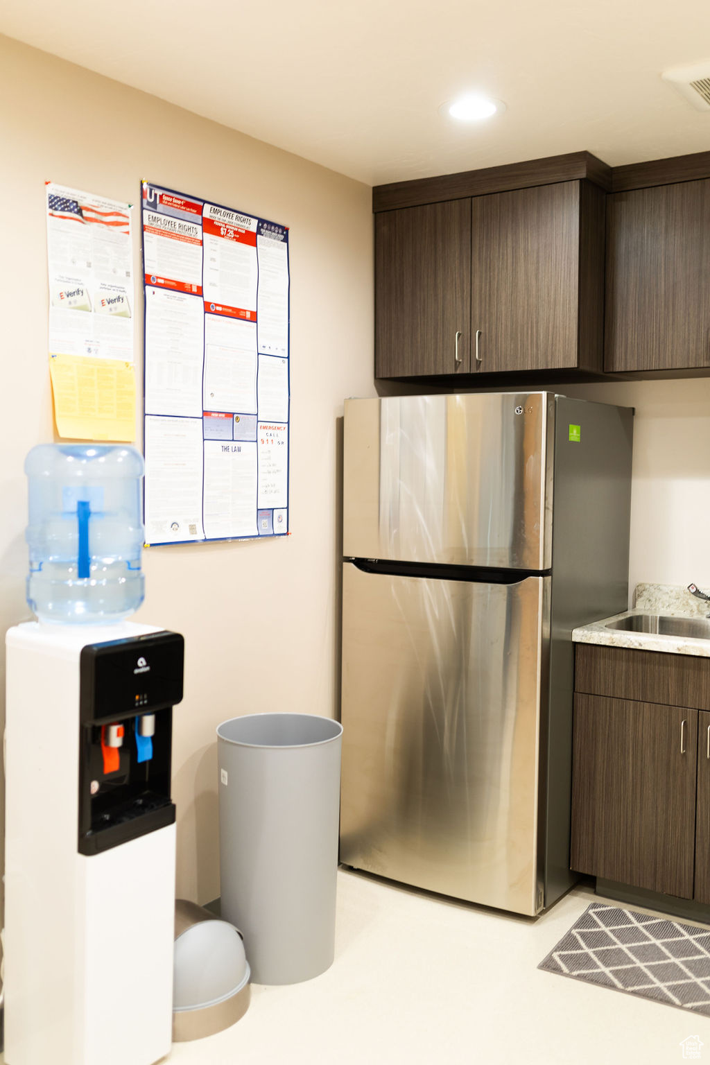 Kitchen with sink, dark brown cabinets, and stainless steel refrigerator