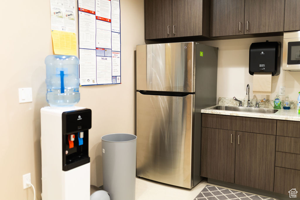 Kitchen with dark brown cabinetry, sink, and stainless steel appliances