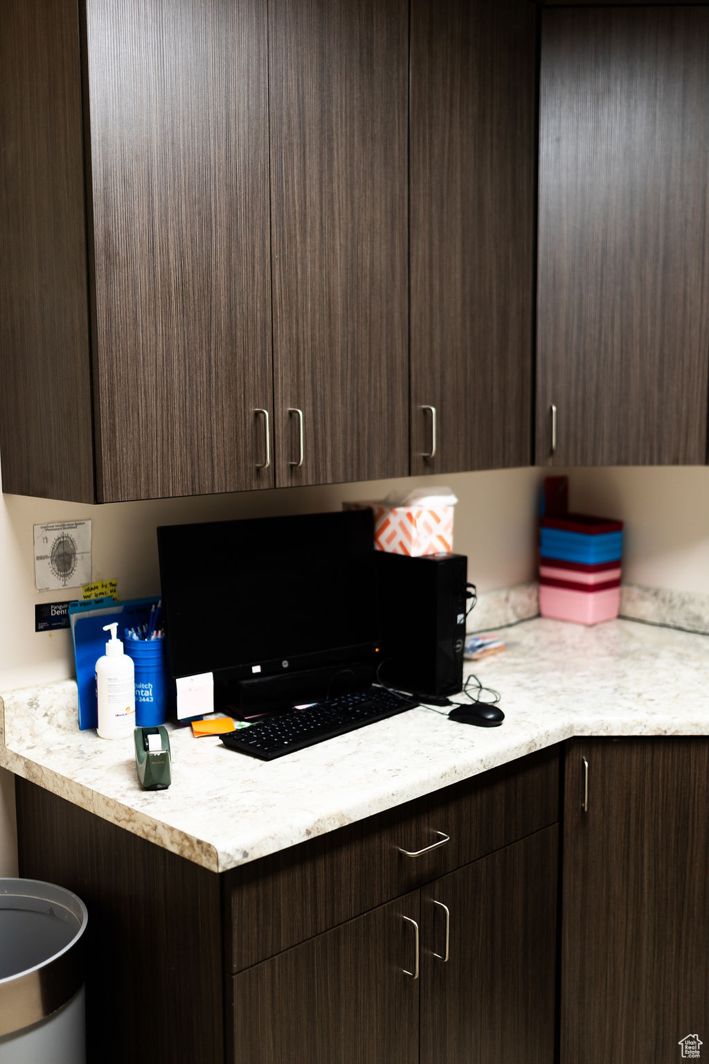 Kitchen featuring light stone countertops and dark brown cabinets