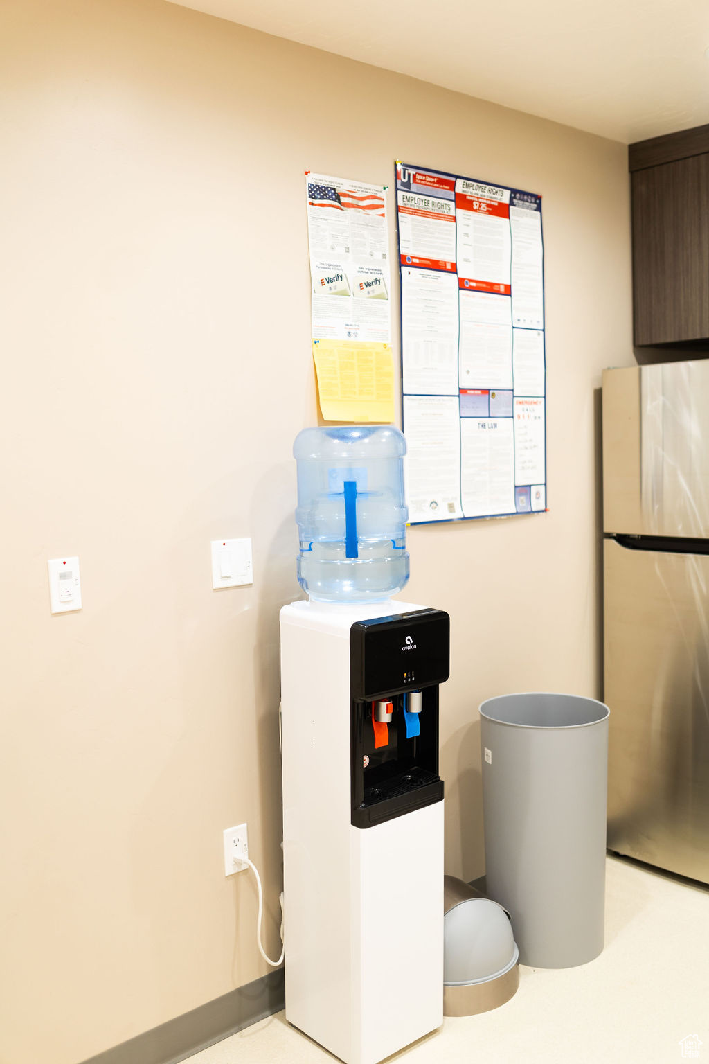 Interior space with dark brown cabinets and stainless steel fridge