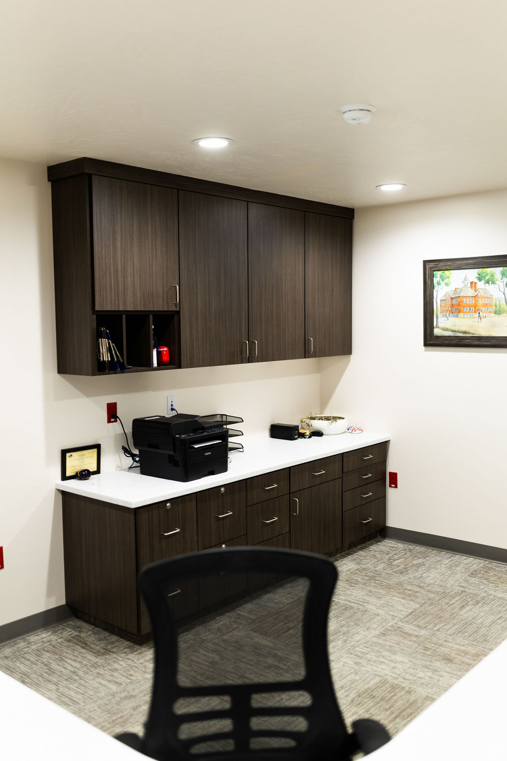 Kitchen featuring light carpet and dark brown cabinets