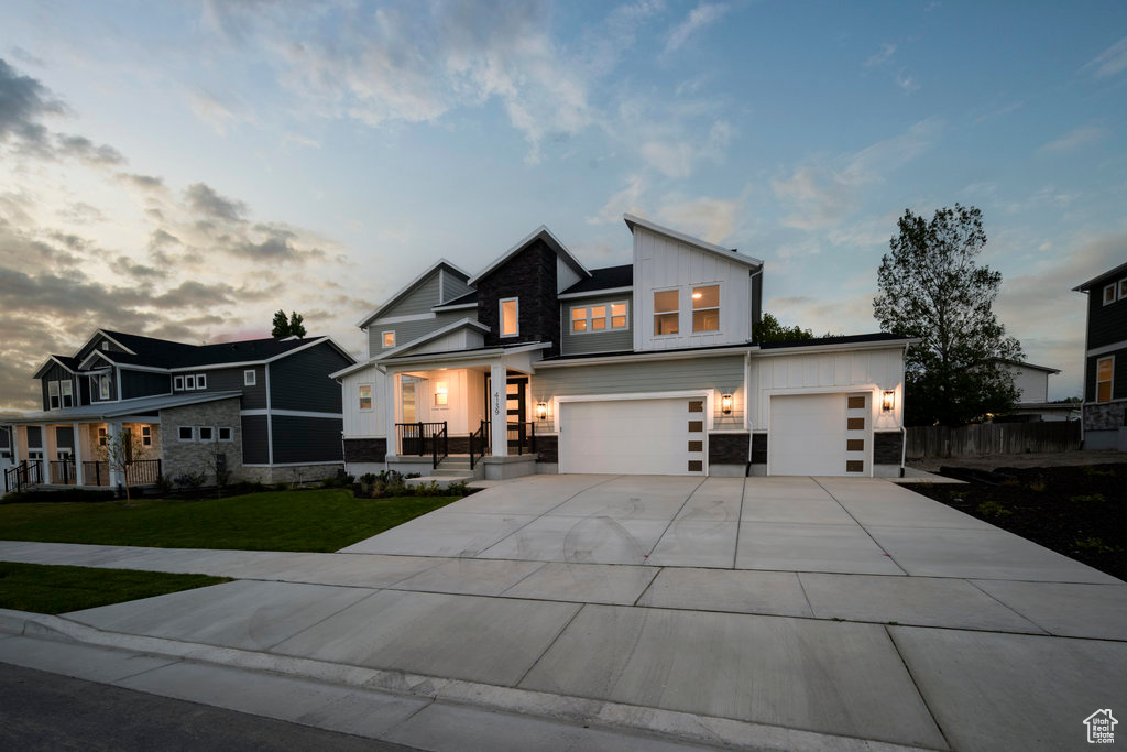 View of front of property with a yard and a garage