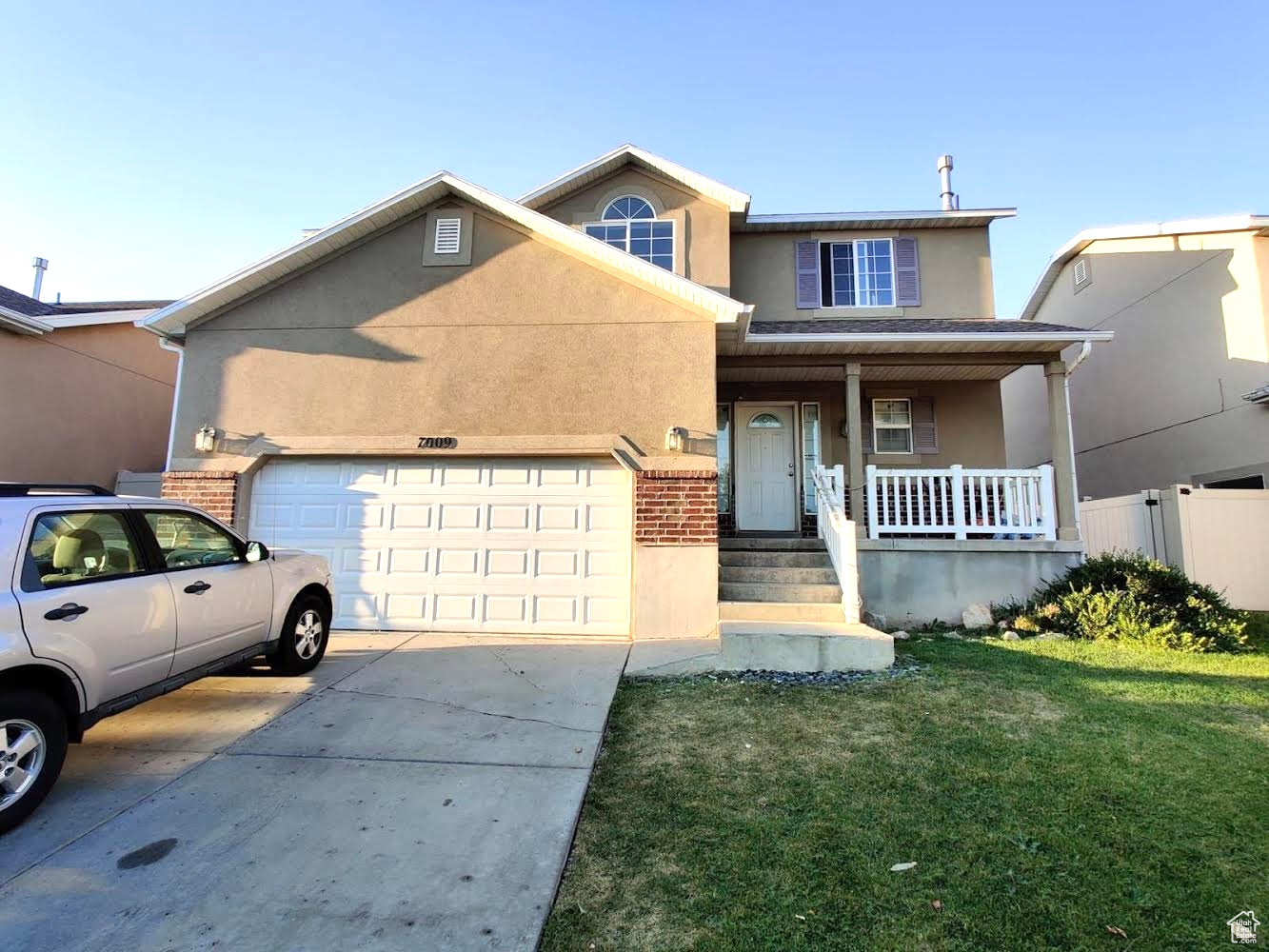 View of front of property with covered porch and a front lawn