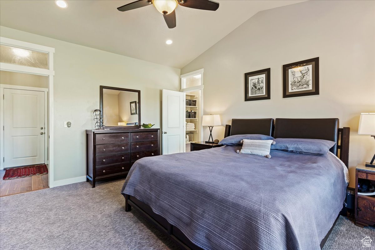 Carpeted bedroom with lofted ceiling and ceiling fan