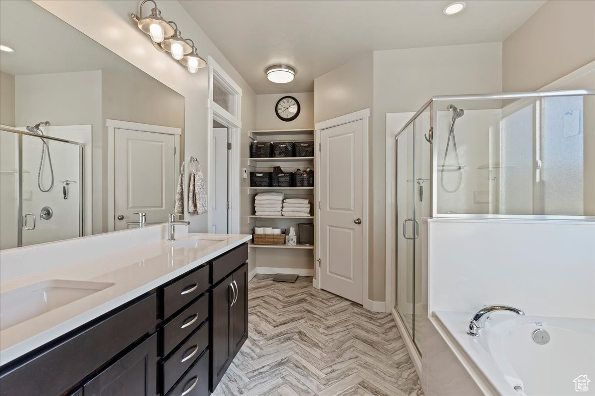 Bathroom with vanity, parquet floors, and shower with separate bathtub