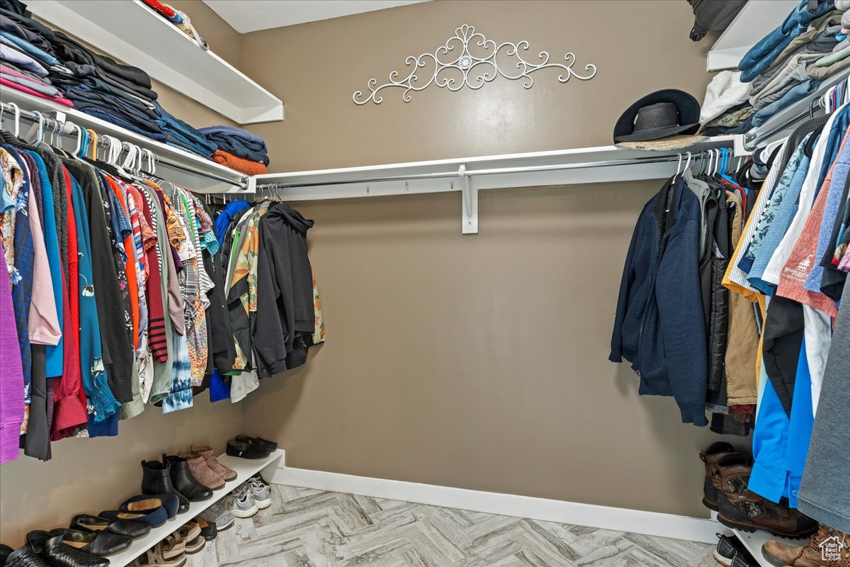 Walk in closet with light parquet flooring