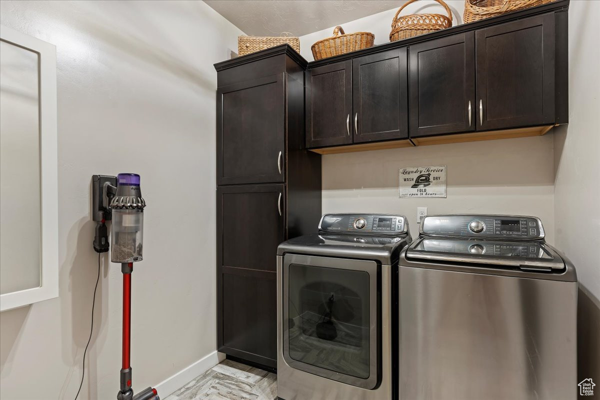 Laundry room with washer and clothes dryer and cabinets