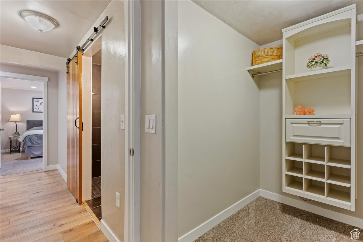 Corridor featuring a barn door and light hardwood / wood-style flooring