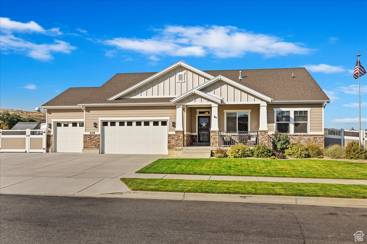 Craftsman house with a garage, a front lawn, and covered porch