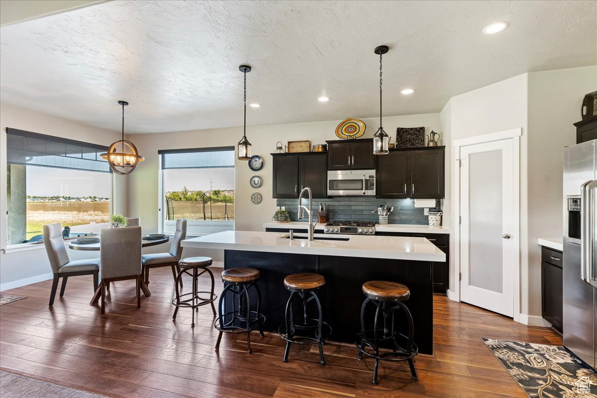 Kitchen featuring an island with sink, plenty of natural light, and stainless steel appliances