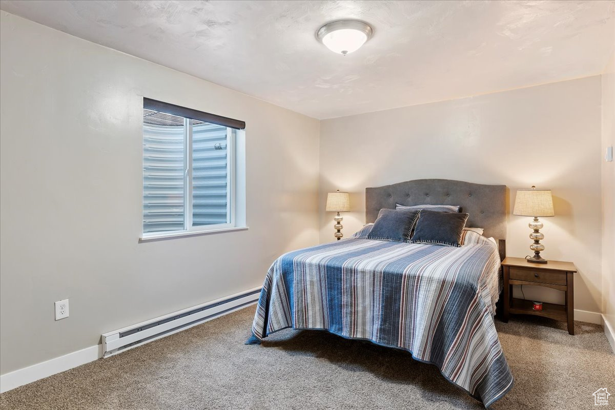 Carpeted bedroom with a baseboard radiator