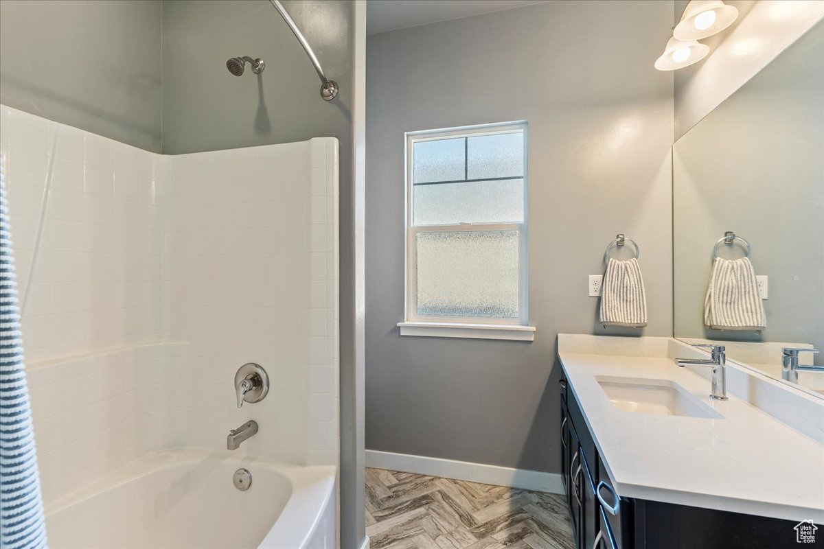 Bathroom featuring shower / bath combination, parquet floors, and vanity