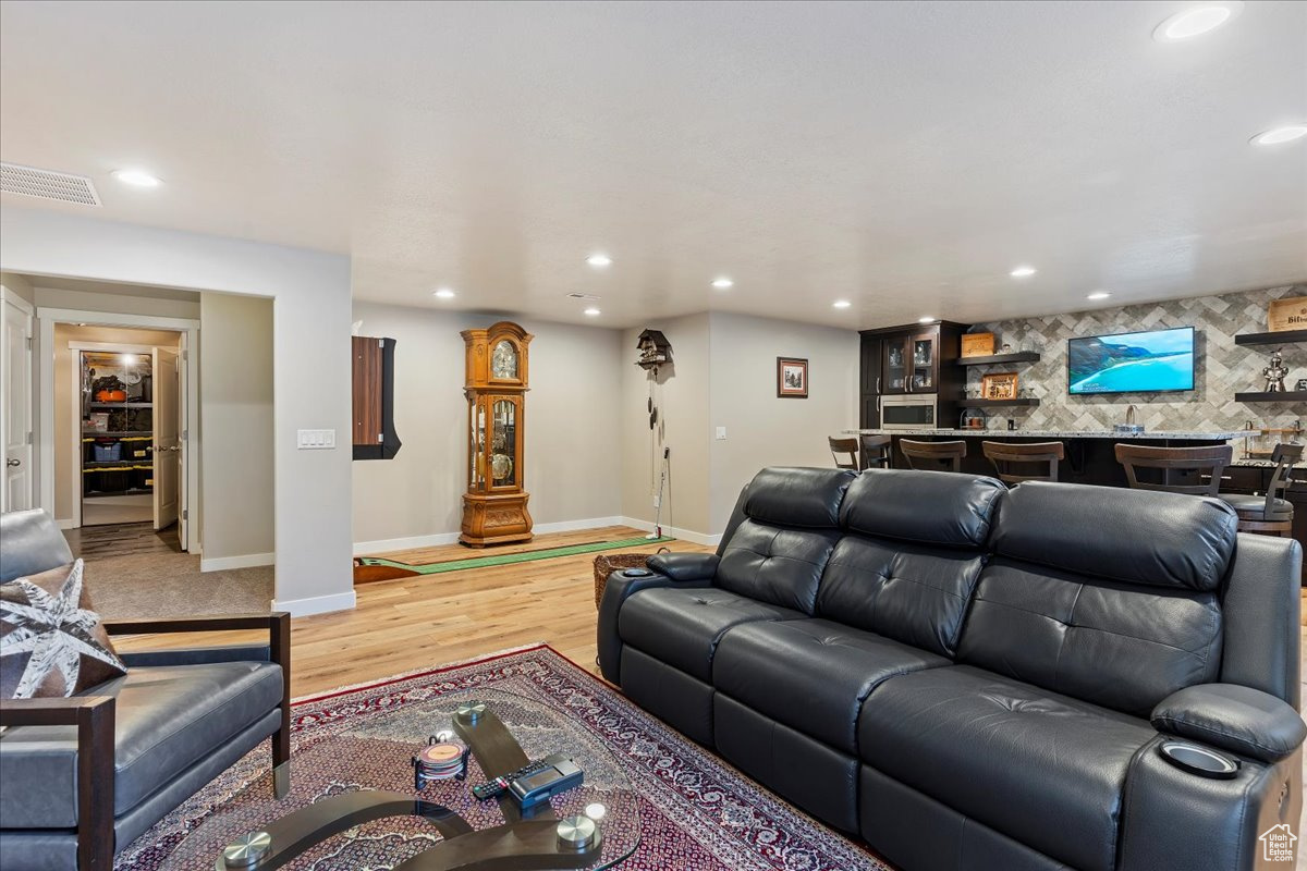 Living room featuring bar and light hardwood / wood-style floors